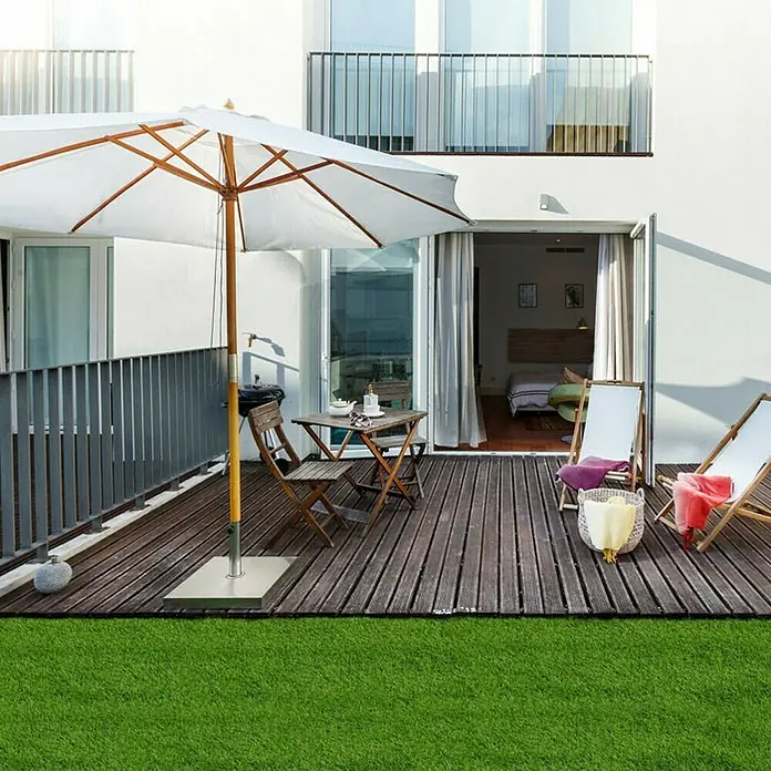 Kunstrasen Tosca - 400 x 200 cm, Grün - Terrasse mit Holzdeck, Sonnenschirm und Gartenmöbeln. Genießen Sie entspannte Stunden im Freien mit diesem stilvollen Outdoor-Bereich.