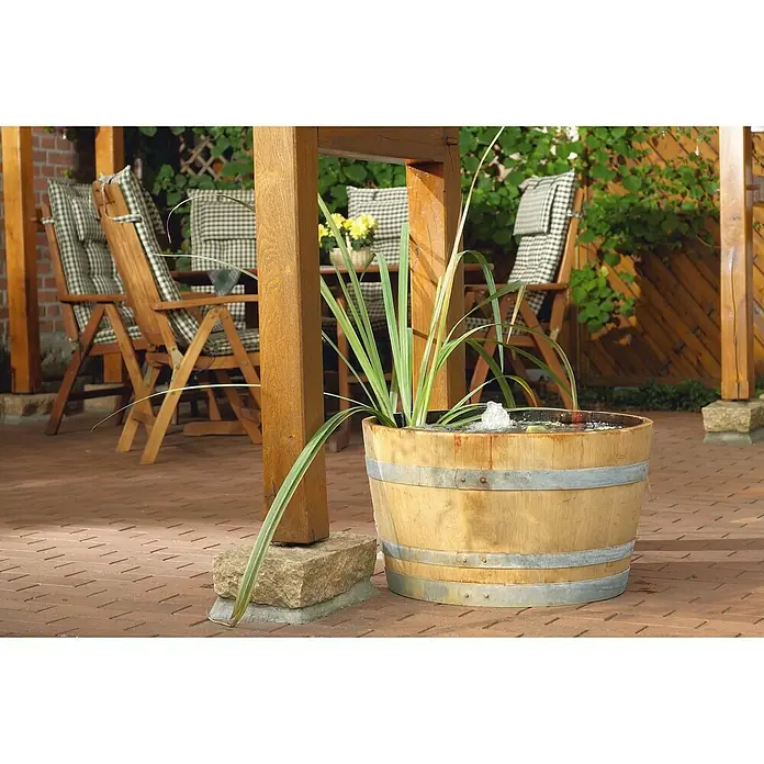 Oase Unterwasserfilter Filtral UVC 6000 - 11 W, Teichgröße: 6 m³ - Nahaufnahme eines dekorativen Holzfasses, das als Mini-Teich mit einer Springbrunnenfunktion und Wasserpflanzen dient. Ideal für den Garten.