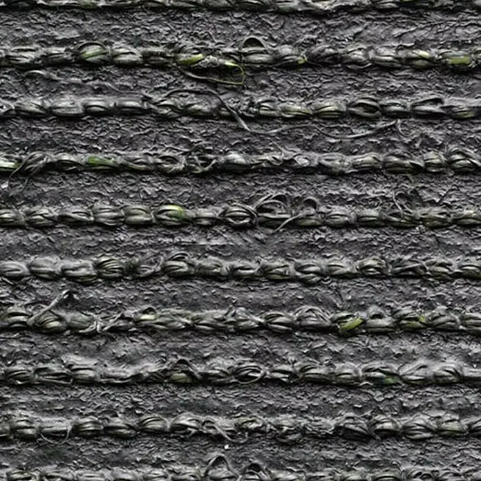 Kunstrasen Oxford - 1.900 x 200 cm, Grün - Nahaufnahme von Kunstrasen mit dunklen Fasern und unebener Textur, ideal für Sportplätze und Gärten.