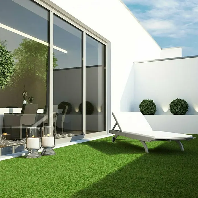Kunstrasen Terraza - 250 x 100 cm, Grün - Moderne Terrasse mit Kunstrasen und einer weißen Sonnenliege vor einer weißen Wand mit grünen Büschen.