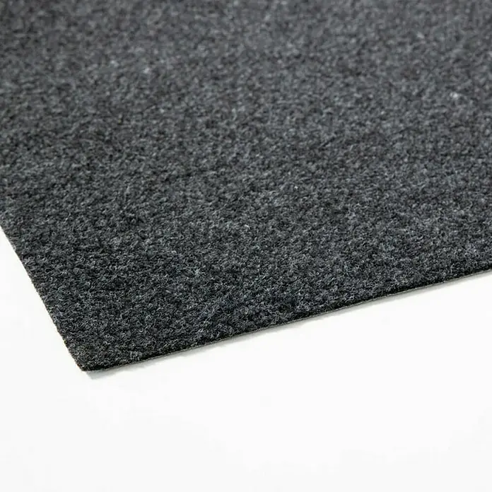 Rasenteppich Farbwunder - 1.800 x 200 cm, Schwarz, Mit Drainagenoppen - Nahaufnahme eines grauen Teppichs mit einer feinen Textur und einer klaren Kante, ideal für Bodenbeläge.