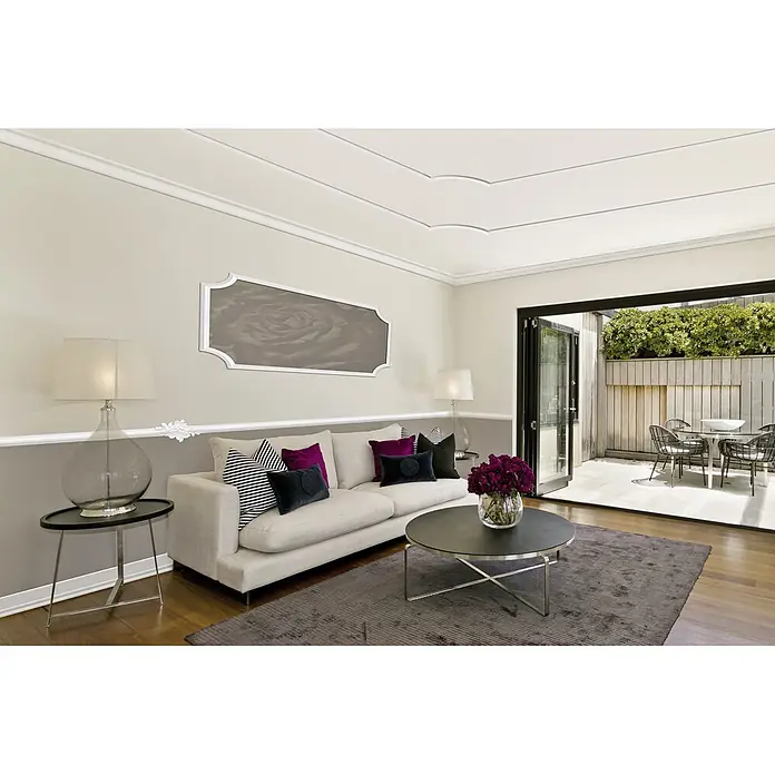 Zierbogen Modern BI 40 - Breite: 40 mm, XPS-Hartschaumplatten - Wohnzimmer mit Couch, Tisch, Lampen und Teppich in Beige- und Grautönen. Die Einrichtung wirkt modern und einladend.