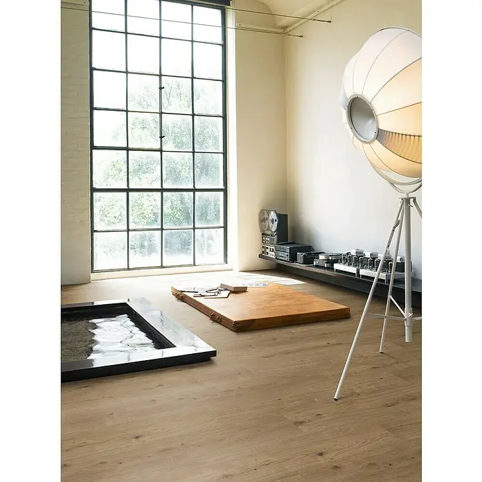 Parador Designboden Modular One - Eiche Atmosphere umbra, Landhausdiele, 1.285 x 194 x 8 mm - Ein helles Zimmer mit einem Holzboden, einem großen Fenster und einer ungewöhnlichen Lampe. Der Holzboden ist das Highlight des Raumes.