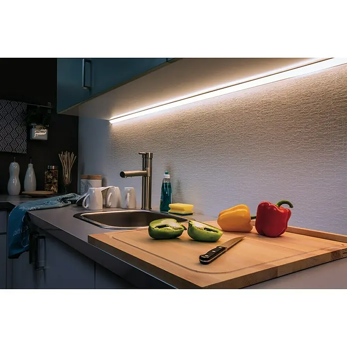 Paulmann MaxLED 500 LED-Band unbeschichtet - Länge: 1 m, Lichtfarbe: Tageslichtweiß, 6 W, 550 lm, Unbeschichtet - Küchenstillleben mit LED-Beleuchtung. Schneidebrett mit Paprika und Messer unter einem Küchenschrank mit LED-Leiste.