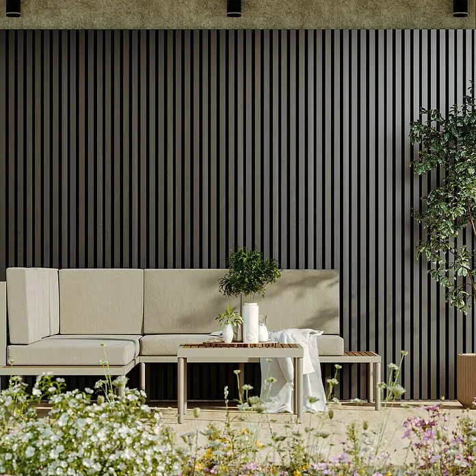 Wandpaneel Outdoor - Grey, WPC, 2.350 x 219 x 26 mm - Elegantes Gartensofa-Set mit Couchtisch. Das helle Sofa und der Tisch harmonieren perfekt mit dem dunklen Hintergrund und den bunten Blumen im Vordergrund.