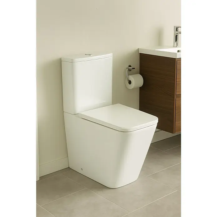 Pack de WC Liena - Sin borde de descarga, Salida WC: Horizontal, Blanco - Primer plano de un inodoro blanco moderno con cisterna y un mueble de lavabo con armario inferior de madera en un baño.
