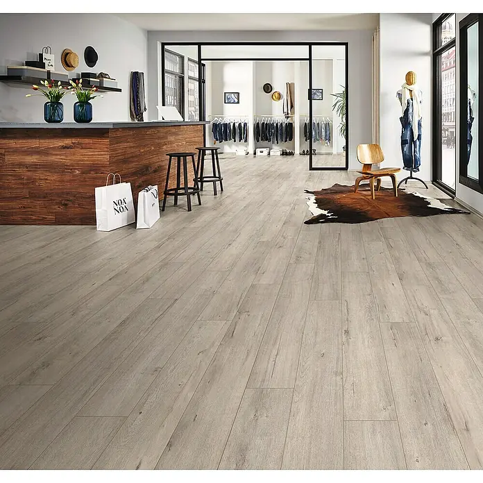 LOGOCLIC Ambienta Laminatmuster Aurora - 300 x 195 x 10 mm, Landhausdiele - Einladender Verkaufsraum mit modernem Bodenbelag in Holzoptik, der eine warme und stilvolle Atmosphäre schafft.