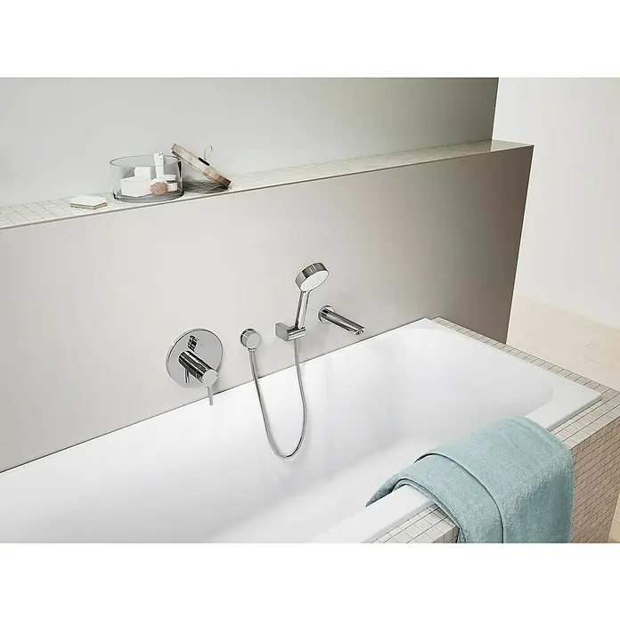 Hansa Vantis UP-Thermostatarmatur - Chrom, Glänzend - Das Bild zeigt eine moderne Badewanne mit einer verchromten Armatur, einer Handbrause und einem hellblauen Handtuch auf dem Badewannenrand.