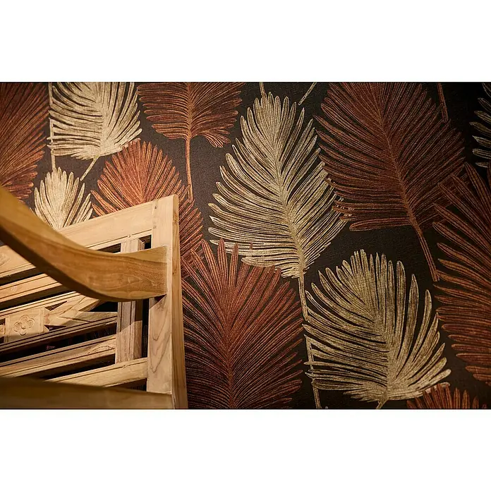 A.S. Création Metropolitan Stories Hot Spots Vliestapete Blätter - Braun-Rot-Beige, Floral, 10,05 x 0,53 m - Detailansicht eines hellen Holzmöbelstücks vor einem Hintergrund mit dekorativen Blattmustern in Gold- und Brauntönen.