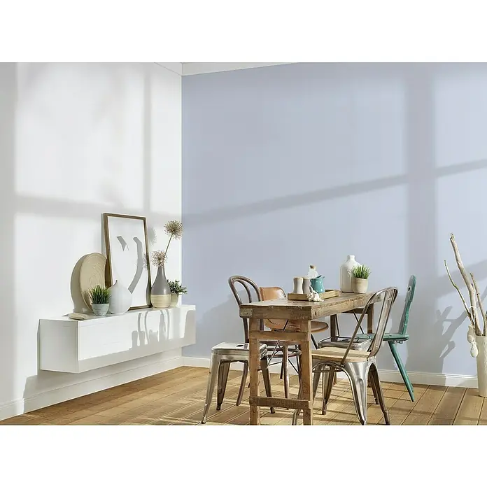 A.S. Création Maison Charme Vliestapete - Blau, Uni, 10,05 x 0,53 m - Ein Esszimmer mit einem Holztisch und Stühlen, dekoriert mit Vasen und Pflanzen auf einer weißen Konsole.