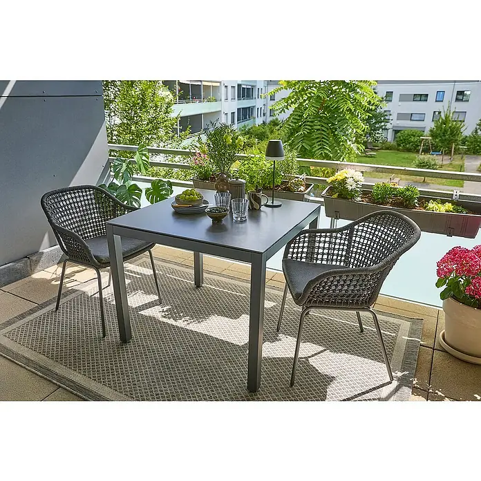Sunfun Balkonmöbel-Set Maja/Sarah Rope - 3 -tlg., Aluminium, Stahl, Sintered Stone, Olefin, Grau - Elegantes Outdoor-Ess-Set mit grauem Tisch und zwei Rattanstühlen auf einem Balkon mit Pflanzen und Grün.