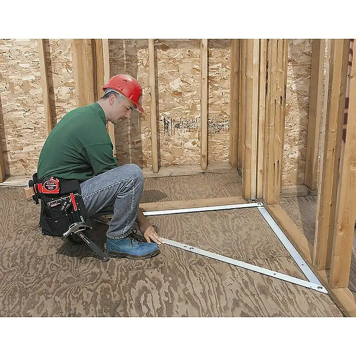 Bauwinkel Verstellbar - Material: Aluminium - Ein Handwerker mit rotem Helm montiert eine dreieckige Metallecke im Rohbau eines Hauses mit Werkzeug an seinem Gürtel.