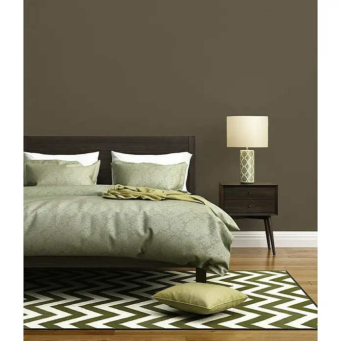 A.S. Création Pintwalls 2 Vliestapete - Braun, Uni, 10,05 x 0,53 m - Schlafzimmer mit einem Bett, einem Nachttisch mit Lampe und einem Teppich mit Zickzackmuster.