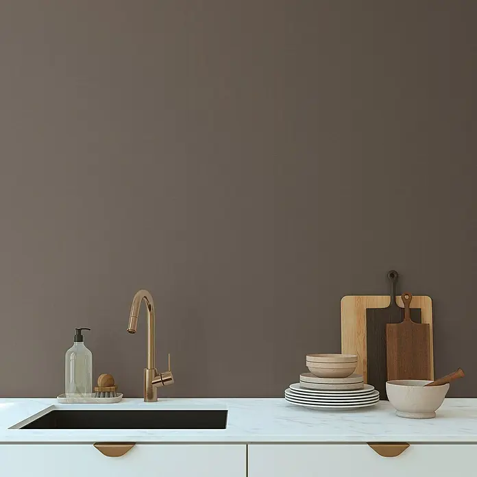A.S. Création Pintwalls 2 Vliestapete - Braun, Uni, 10,05 x 0,53 m - Elegante Küchenspüle mit goldenem Wasserhahn, Geschirr und Schneidebrettern vor einer braunen Wand. Stilvolles Design für moderne Küchen.