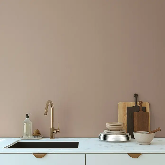 A.S. Création Pintwalls 2 Vliestapete - Braun-Beige, Uni, 10,05 x 0,53 m - Ein moderner Küchentisch mit Spüle, Armatur, Seife, Tellern und Schneidebrettern vor einer braunen Wand.