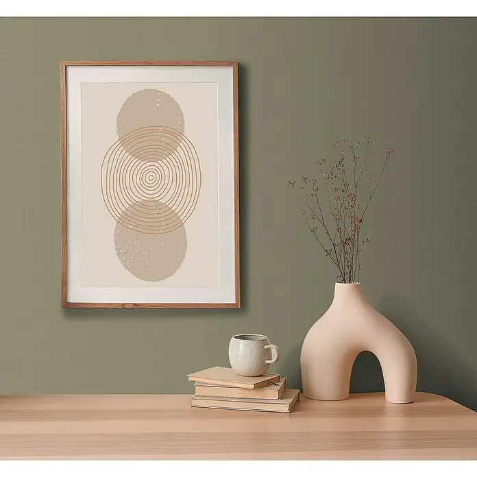 A.S. Création Pintwalls 2 Vliestapete - Grün-Khaki, Uni, 10,05 x 0,53 m - Ein stilvolles Wandbild mit geometrischen Formen, kombiniert mit einer Vase und Büchern auf einem Tisch.