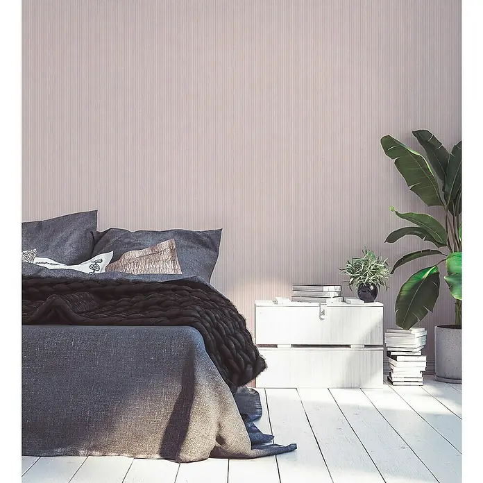A.S. Création Maison Charme Vliestapete - Rosa-Creme, Streifen, 10,05 x 0,53 m - Schlafzimmer-Interieur mit einem eleganten Bett, einem weißen Nachttisch und einer Zimmerpflanze, die eine ruhige Atmosphäre schaffen.