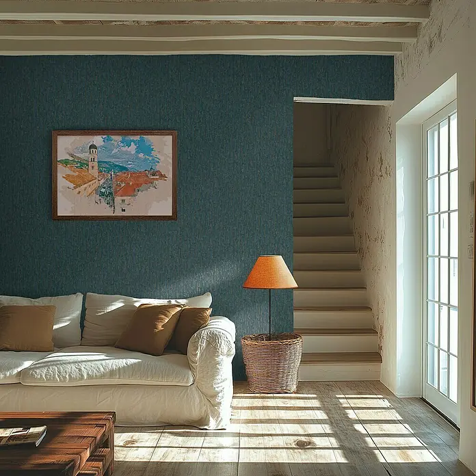 A.S. Création Metropolitan Stories Hot Spots Vliestapete Grafik - Blau-Gold-Metallic, Grafisch, 10,05 x 0,53 m - Elegantes Wohnzimmer mit blau gemusterter Tapete, bequemer Couch, Lampe und einem gerahmten Gemälde an der Wand.