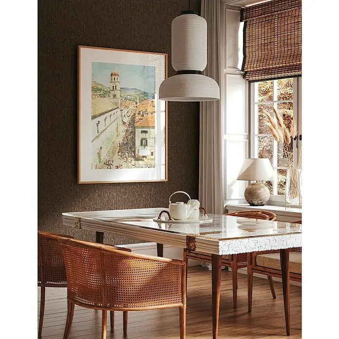 A.S. Création Metropolitan Stories Hot Spots Vliestapete Grafik - Braun-Metallic, Grafisch, 10,05 x 0,53 m - Der Esstisch mit Stühlen aus Rattan und der Hängeleuchte im Zimmer mit brauner Wand wirkt sehr einladend und gemütlich.