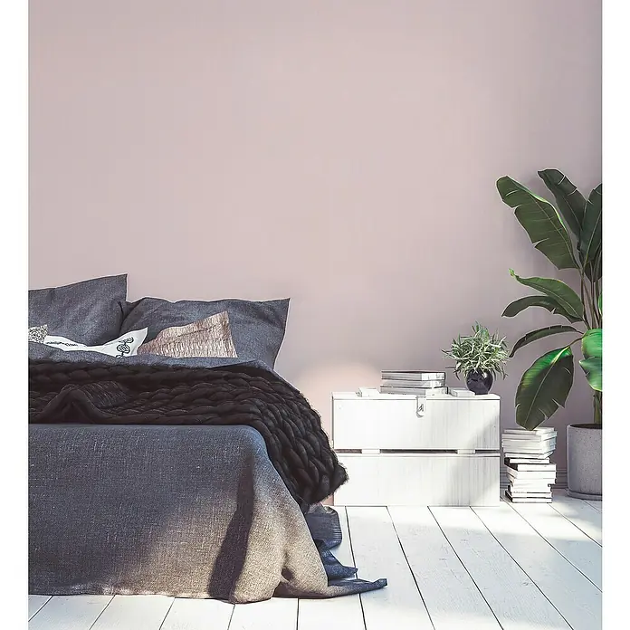 A.S. Création Maison Charme Vliestapete - Rosa, Uni, 10,05 x 0,53 m - Einladendes Schlafzimmer mit stilvoller grauer Bettwäsche, einem schlichten Nachttisch und einer dekorativen Zimmerpflanze für eine ruhige Atmosphäre.