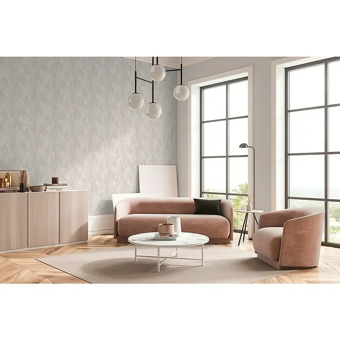 A.S. Création Daniel Hechter 7 Vliestapete Grafische Dreiecke - Beige-Creme-Grau, Grafisch, 10,05 x 0,53 m - Ein stilvolles Wohnzimmer mit einem modernen Sofa, einem Sessel und einem Couchtisch auf einem hellen Teppich. Die Einrichtung ist hell und einladend.