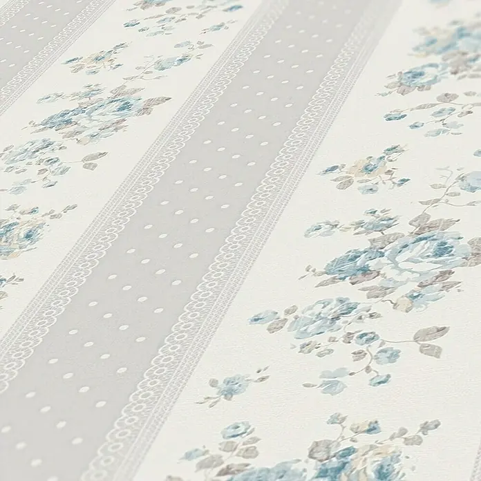 A.S. Création Maison Charme Vliestapete Vertikale Blümchen - Grau-Blau-Weiß, Floral, 10,05 x 0,53 m - Nahaufnahme einer Tapete mit blau-grauem Blumenmuster und dekorativen Streifen mit Spitzenborte und Punkten.