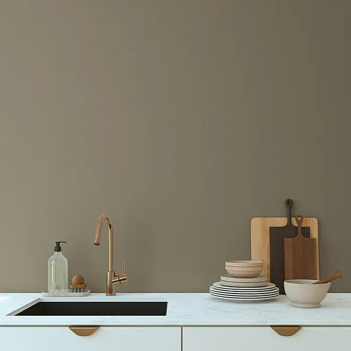 A.S. Création Pintwalls 2 Vliestapete - Grün-Khaki, Uni, 10,05 x 0,53 m - Eine moderne Küchenspüle mit goldenem Wasserhahn, Seifenspender und Geschirr auf einer weißen Marmorarbeitsplatte.