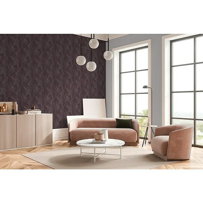 A.S. Création Daniel Hechter 7 Vliestapete Grafische Dreiecke - Lila-Grau-Rosé, Grafisch, 10,05 x 0,53 m - Wohnzimmer mit stilvollem Sofa, Sessel und Couchtisch auf einem Teppich. Eine elegante Beleuchtung rundet das Ambiente ab.
