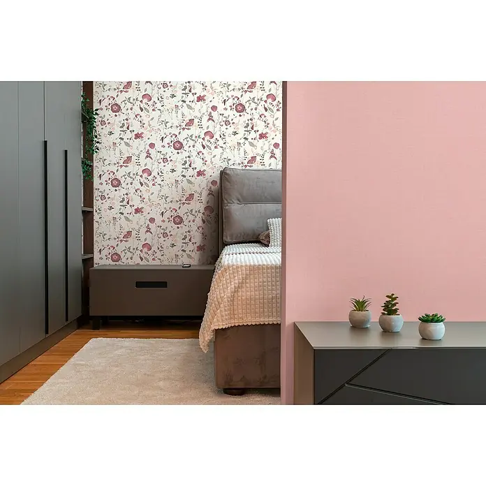 A.S. Création Pintwalls 2 Vliestapete Blumen - Weiß-Violett-Rosa, Floral, 10,05 x 0,53 m - Schlafzimmer Interieur mit floraler Tapete, grauem Kleiderschrank und Nachttisch. Zimmerpflanzen auf dem Nachttisch sorgen für eine gemütliche Atmosphäre.