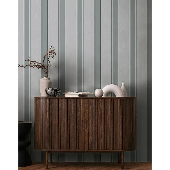 A.S. Création Michalsky Metropolis Vliestapete - Grau, Streifen, 10,05 x 0,53 m - Detailansicht eines Holzschranks mit minimalistischer Dekoration und gestreifter Wand.