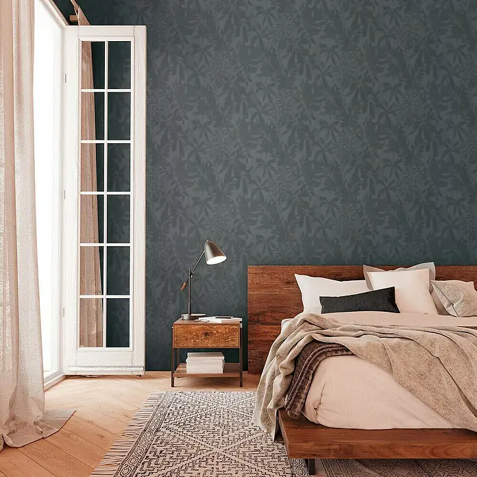 A.S. Création Daniel Hechter 7 Vliestapete Florale Schatten - Grau-Schwarz, Floral, 10,05 x 0,53 m - Schlafzimmer mit einem Kingsize-Bett aus Holz, Nachttisch und gemusterter Tapete in einem gemütlichen Interieur.