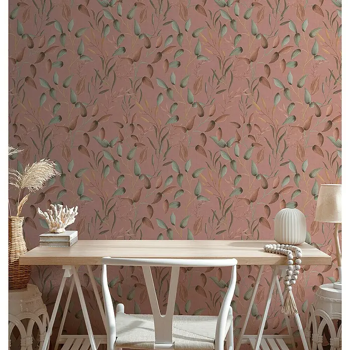 A.S. Création Pintwalls 2 Vliestapete Blätterranke - Rosa-Grün-Rot, Floral, 10,05 x 0,53 m - Nahaufnahme eines stilvollen Arbeitsbereichs mit einem hellen Holztisch vor einer Wand mit Blattmuster.