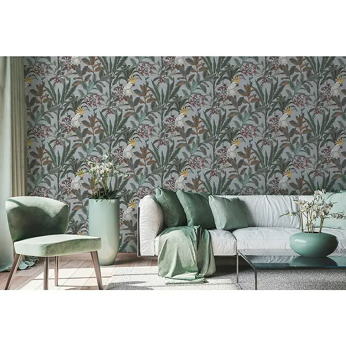 A.S. Création Pintwalls 2 Vliestapete Dschungel - Grau-Blau-Grün, Floral, 10,05 x 0,53 m - Einladendes Wohnzimmer mit auffälliger floraler Tapete, mintgrünem Sessel und Sofa mit passenden Kissen, die eine ruhige und stilvolle Atmosphäre schaffen.