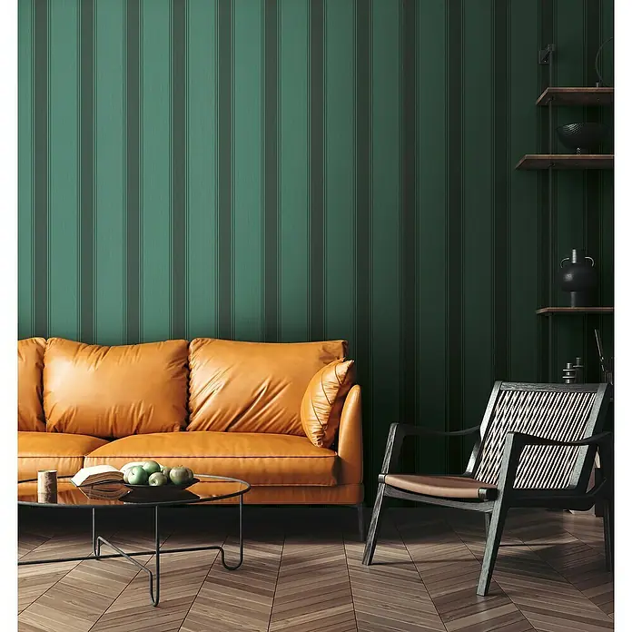 A.S. Création Metropolitan Stories Vliestapete - Grün-Schwarz-Grau, Streifen, 10,05 x 0,53 m - Wohnzimmer mit senfgelbem Sofa, Sessel und grün gestreifter Wand. Stilvolles Interieur mit gemütlicher Atmosphäre.