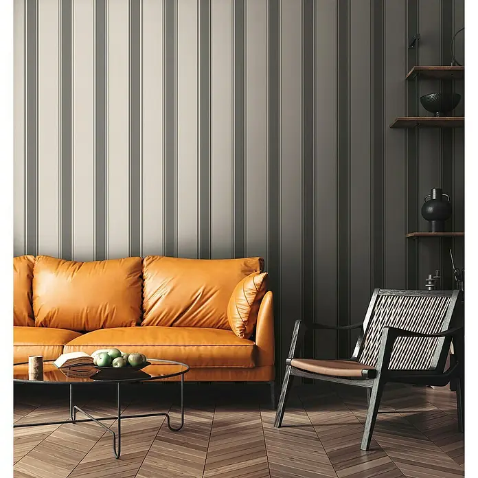 A.S. Création Michalsky Metropolis Vliestapete - Beige-Grau, Streifen, 10,05 x 0,53 m - Einladendes Wohnzimmer mit einem ockerfarbenen Ledersofa, einem modernen Stuhl und einem eleganten Couchtisch auf einem Holzboden.