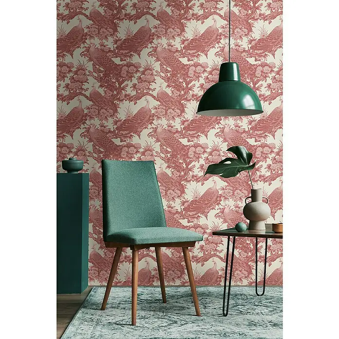 A.S. Création Michalsky Metropolis Vliestapete Dschungel - Rot-Creme-Rosa, Floral, 10,05 x 0,53 m - Einrichtungsszene mit einem mintfarbenen Stuhl, einer Stehlampe und einem Beistelltisch vor einer Wand mit Pfauenmotivtapete.