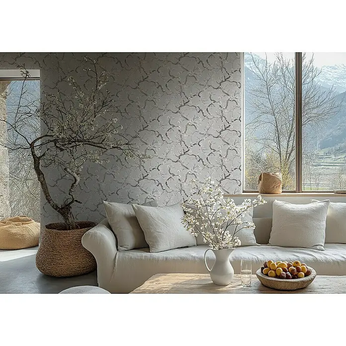 A.S. Création Metropolitan Stories Hot Spots Vliestapete Kirschblüte - Grau-Rosa-Schwarz, Floral, 10,05 x 0,53 m - Elegantes Wohnzimmer mit einem stilvollen Sofa, floraler Tapete und frischen Blumenarrangements, die eine entspannende Atmosphäre schaffen.