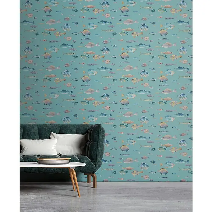 A.S. Création Pintwalls 2 Vliestapete Fische - Blau-Bunt-Violett, Tieroptik, 10,05 x 0,53 m - Die Nahaufnahme zeigt ein modernes Wohnzimmer mit einem stilvollen grünen Sofa vor einer verspielten Fisch-Tapete, die dem Raum eine frische Note verleiht.