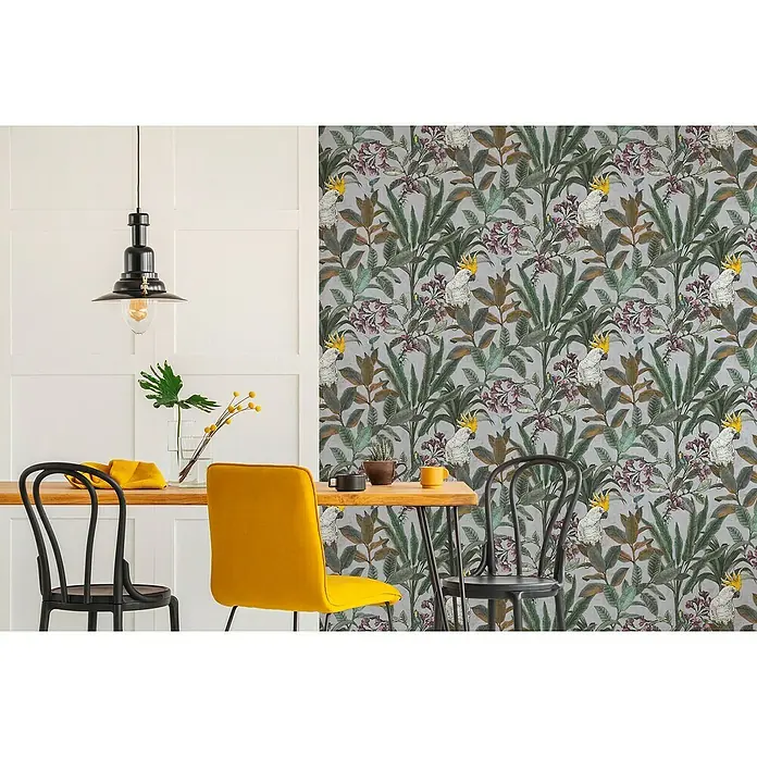 A.S. Création Pintwalls 2 Vliestapete Dschungel - Grau-Blau-Grün, Floral, 10,05 x 0,53 m - Das Esszimmer zeigt eine stilvolle Tapete mit tropischen Blättern und Kakadus, die eine exotische und lebendige Atmosphäre schafft.