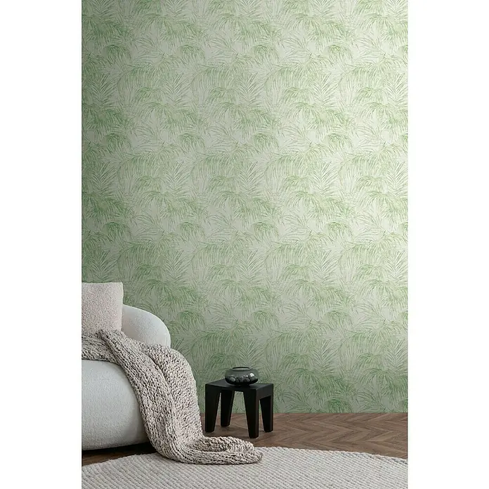 A.S. Création Michalsky Metropolis Vliestapete Farn - Creme-Grün, Floral, 10,05 x 0,53 m - Nahaufnahme einer Wand mit tropischer Palmblatt-Tapete, die eine ruhige und stilvolle Raumatmosphäre schafft.