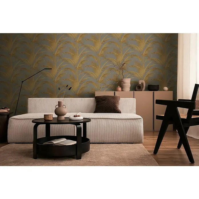 A.S. Création Metropolitan Stories Vliestapete Palmwedel - Grau-Gold-Metallic, Floral, 10,05 x 0,53 m - Elegantes Wohnzimmer mit beigem Sofa, schwarzem Tisch und passenden Möbeln vor einer gemusterten Tapete.