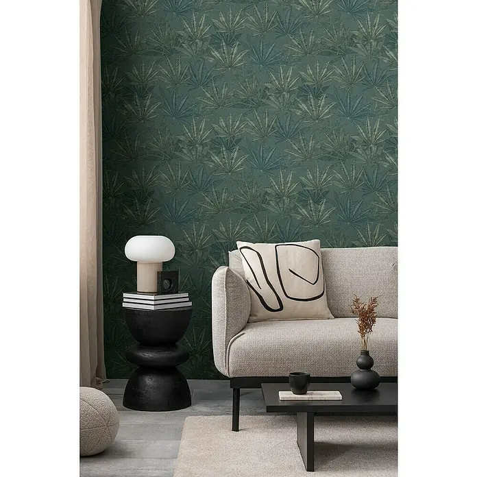 A.S. Création Michalsky Metropolis Vliestapete Hanfblätter - Grau-Grün-Blau, Floral, 10,05 x 0,53 m - Wohnzimmer mit einem bequemen Sofa, einem Couchtisch und einem Beistelltisch mit einer Lampe, die ein gemütliches Ambiente schaffen.