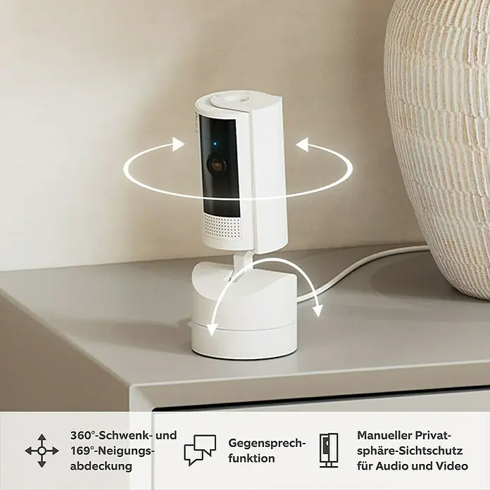 Ring Innenkamera beweglich Pan-Tilt Indoor Camera - 1.080 Pixel (Full HD), Weiß - Das Bild zeigt eine Ring Sicherheitskamera mit Schwenk- und Neigungsfunktion auf einem Tisch.