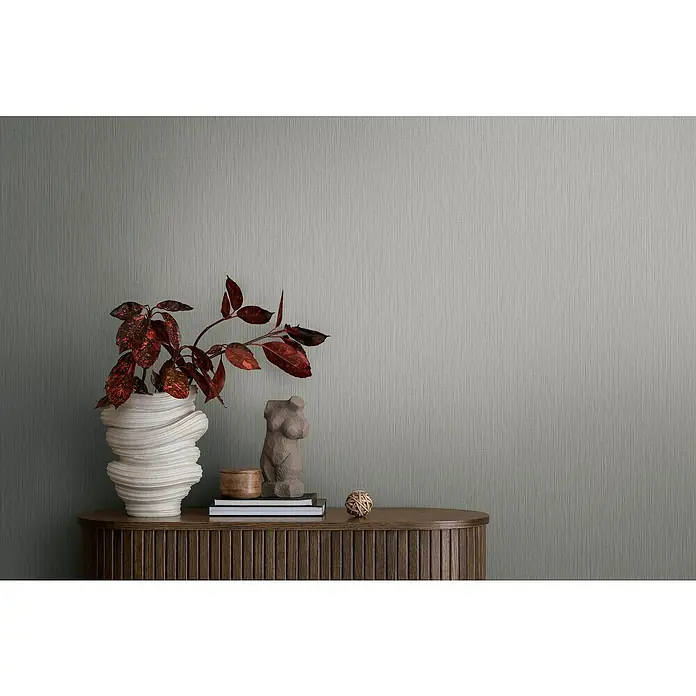 A.S. Création Michalsky Metropolis Vliestapete - Mittelgrau, Uni, 10,05 x 0,53 m - Dekorative Nahaufnahme einer Kommode mit Blumenvase und einer kleinen Skulptur, die eine elegante und kunstvolle Atmosphäre schafft.