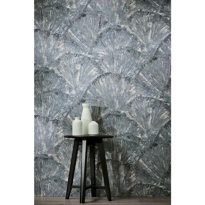 A.S. Création Metropolitan Stories Hot Spots Vliestapete Grafik - Blau-Grau-Metallic, Grafisch, 10,05 x 0,53 m - Dekorative weiße Vasen stehen auf einem schwarzen Beistelltisch vor einer stilvollen, gemusterten Wand.