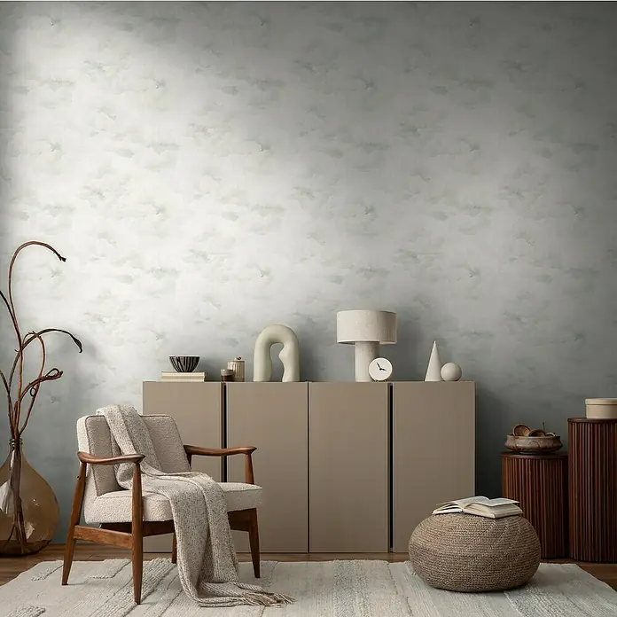 A.S. Création Michalsky Metropolis Vliestapete Wolken - Weiß-Grau-Creme, Sonstiges, 10,05 x 0,53 m - Einladender Wohnraum mit einem hellen Sessel und einem beigen Sideboard, dekoriert mit einer stilvollen Lampe und abstrakten Objekten.