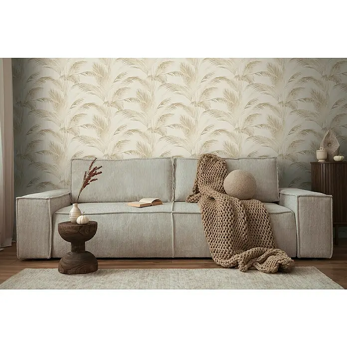 A.S. Création Michalsky Metropolis Vliestapete Palmwedel - Creme-Beige-Braun, Floral, 10,05 x 0,53 m - Einladendes Wohnzimmer mit einem beigen Cordsofa, das mit einer Strickdecke und Kissen dekoriert ist, vor einer Wand mit Palmenmuster.