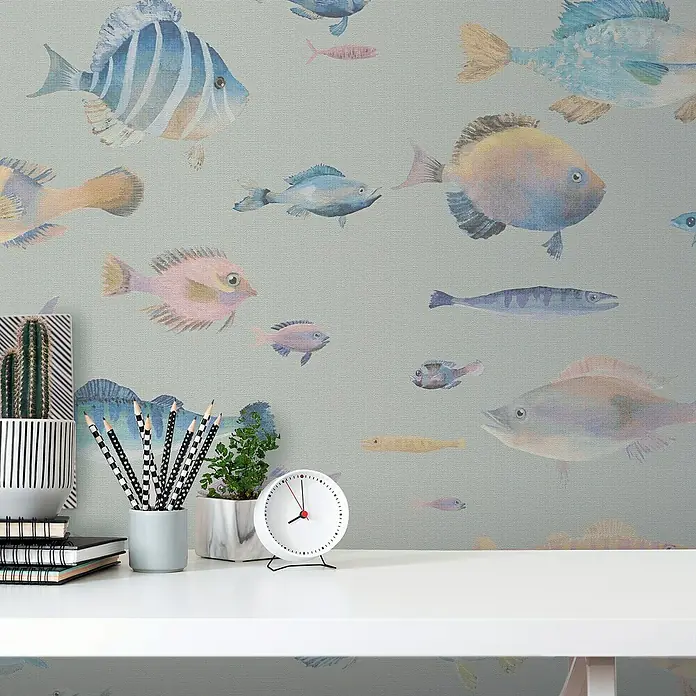 A.S. Création Pintwalls 2 Vliestapete Fische - Grau-Bunt-Violett, Tieroptik, 10,05 x 0,53 m - Dekoratives Stillleben mit einer weißen Uhr, Stiften, Notizbüchern und Pflanzen vor einer Wand mit Fischmuster.
