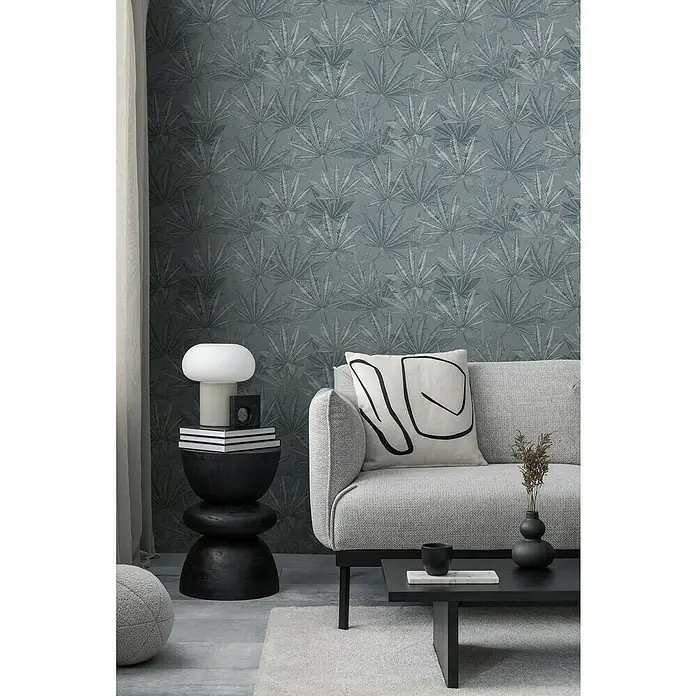 A.S. Création Michalsky Metropolis Vliestapete Hanfblätter - Grau, Floral, 10,05 x 0,53 m - Elegantes Interieur mit Couch und Beistelltisch vor einer Wand mit Blattmuster-Tapete.