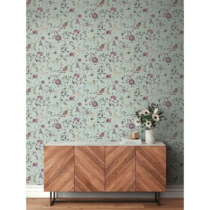 A.S. Création Pintwalls 2 Vliestapete Blumen - Grün-Violett-Gelb, Floral, 10,05 x 0,53 m - Sideboard aus Holz mit Fischgrätmuster, einer Marmorplatte und einem Blumendekor vor einer floralen Tapete für ein stilvolles Wohnambiente.